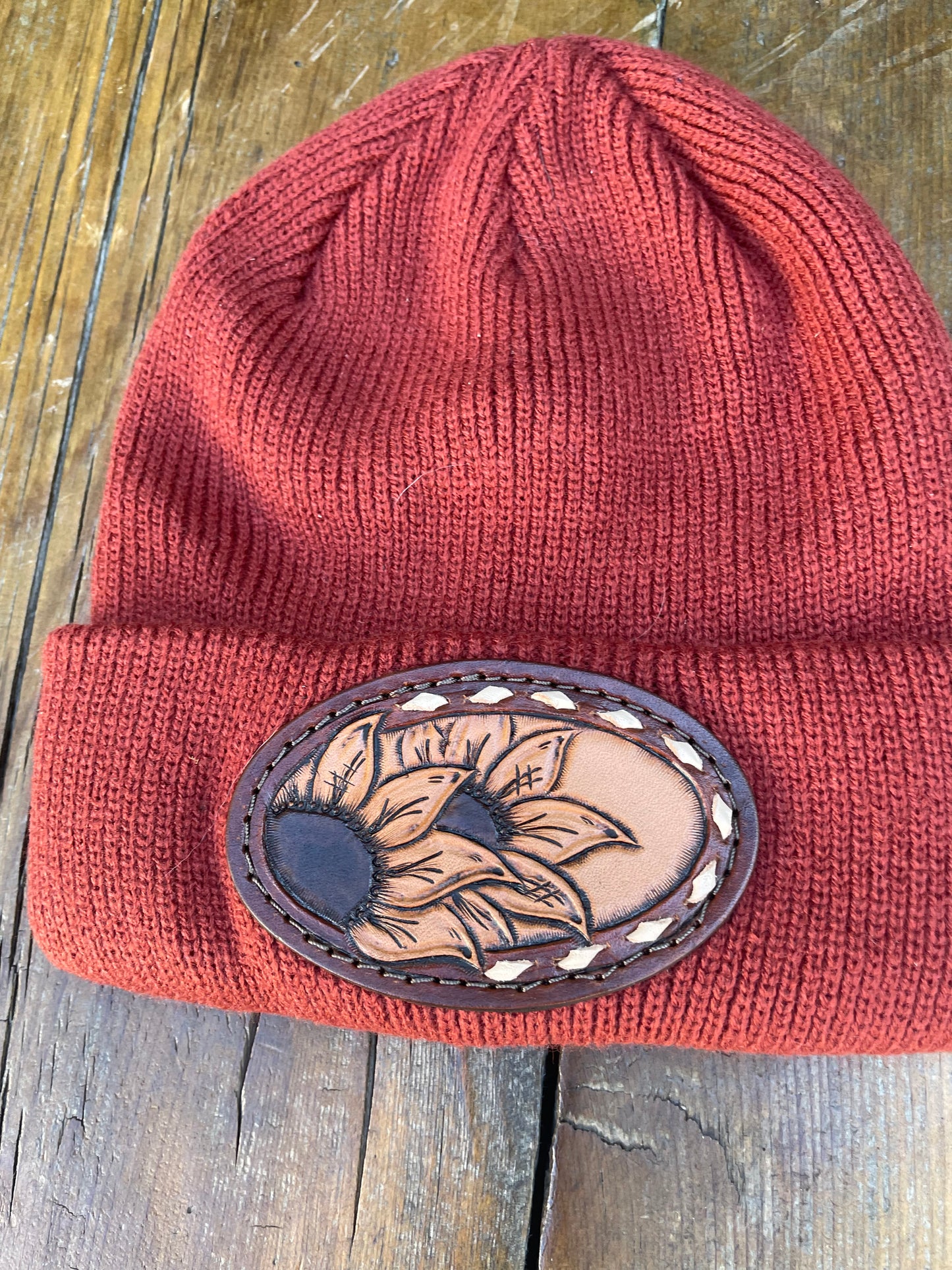 Rust color beanie with sunflower and buck stitch
