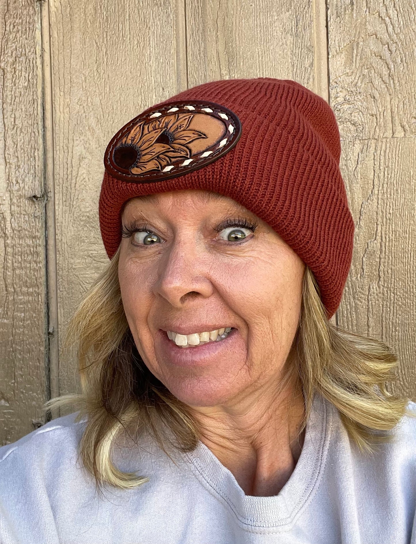 Rust color beanie with sunflower and buck stitch
